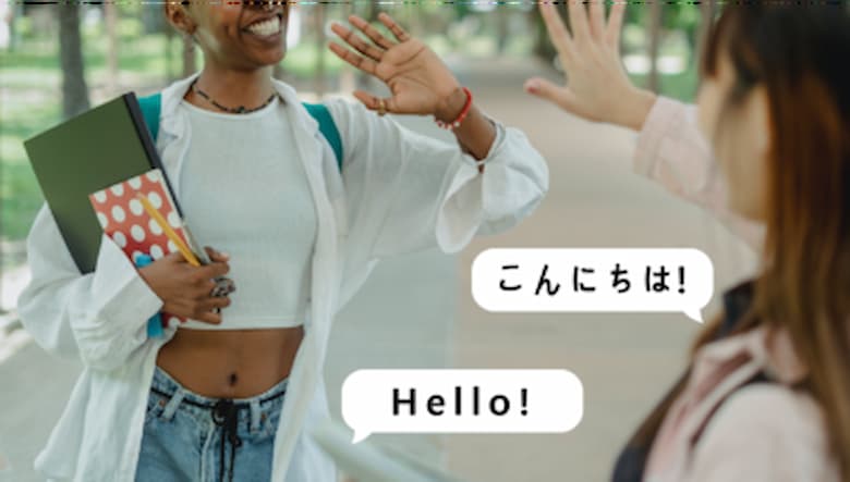 two women are volunteering and waving a hand up. two text bubbles one reads "Hello!"and the other reads "Konichiwa" in Japanese characters