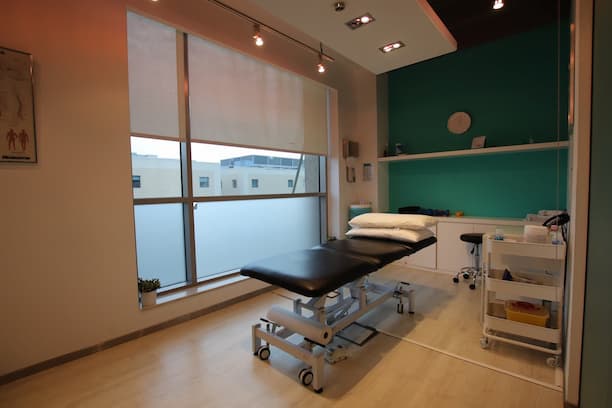 A physio in Tokyo. It shows a patient bed in a room where treatment is done. There are basic sanitary and equipment pictured.