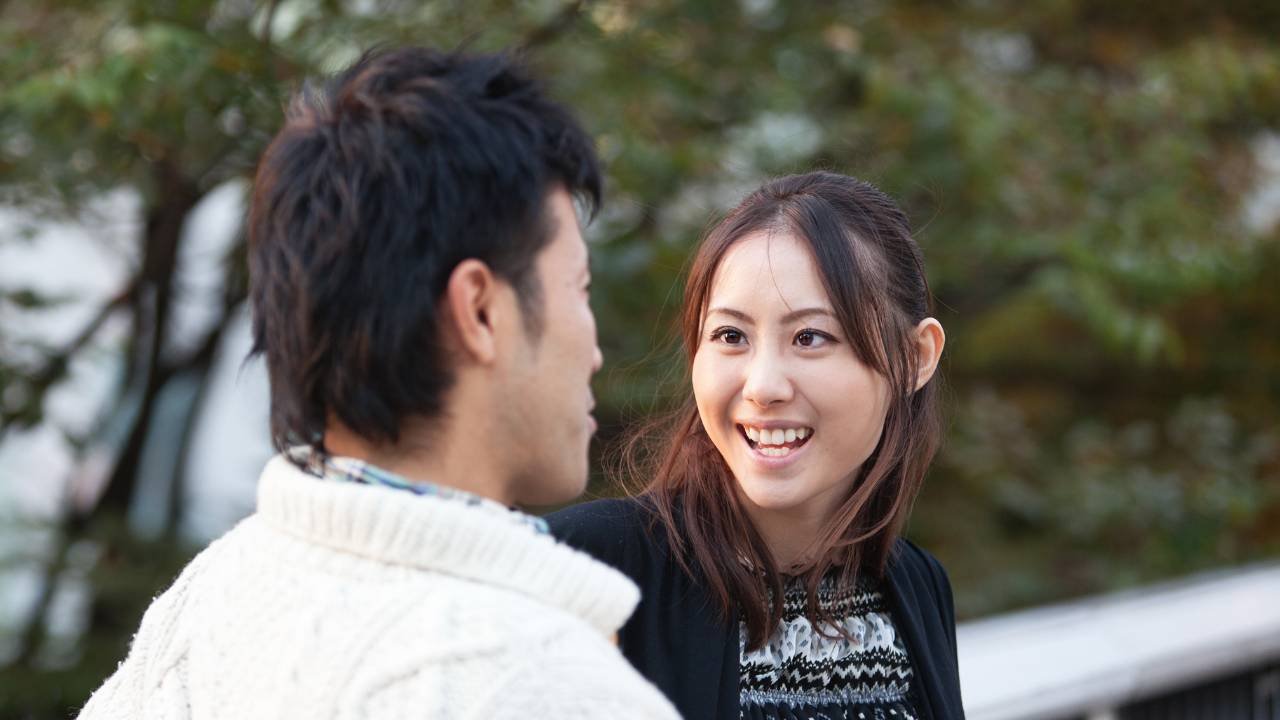 Asian woman smiling and looking at smiling Asian man