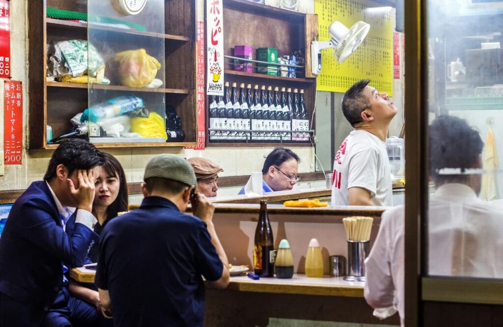A group of people eating in an Izakaya after work.