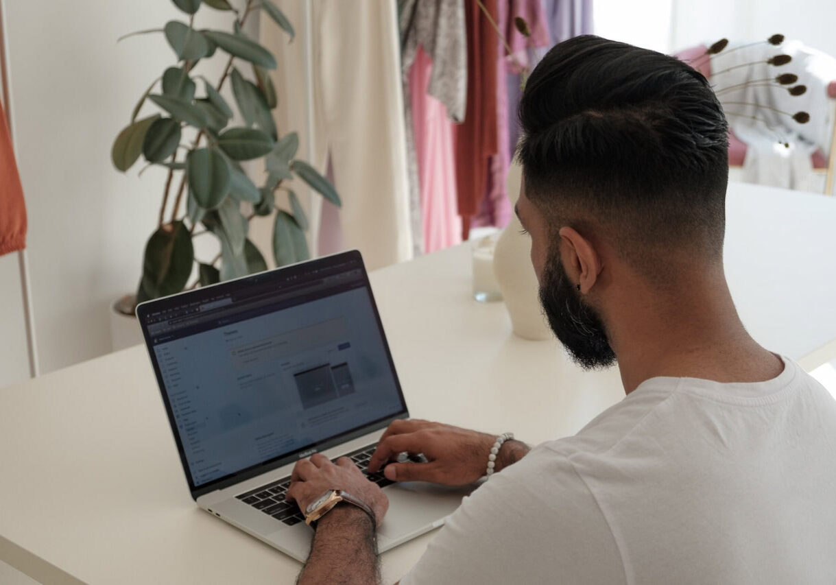 Man sitting on a desk doing online shopping of Japanese Fashion Brands